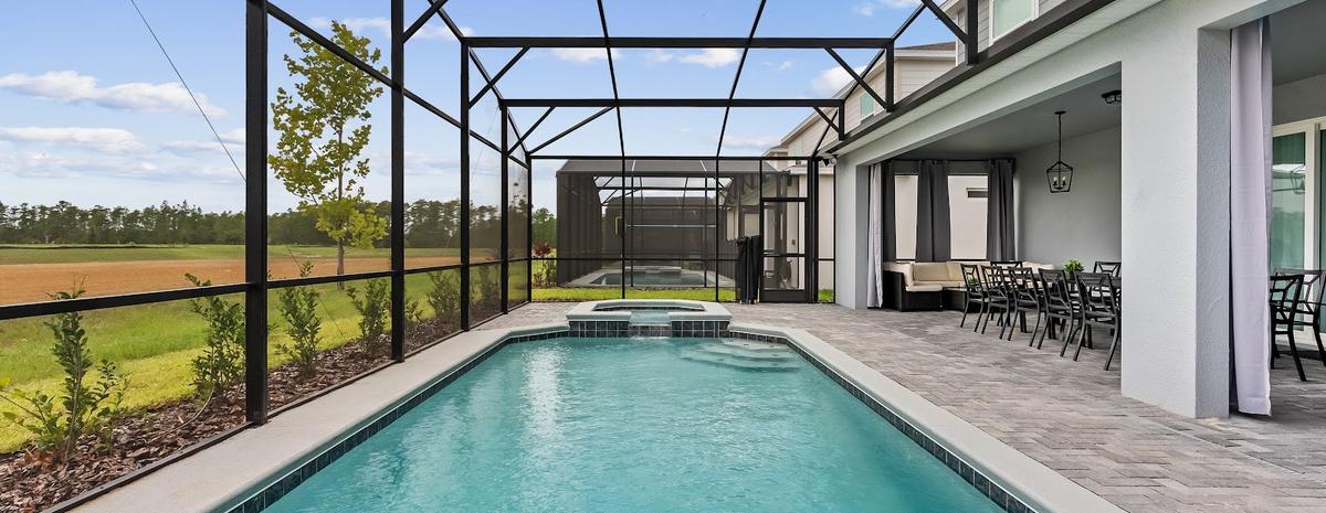 Piscina privativa de uma casa na região de Orlando, com deck coberto e mesa para receber